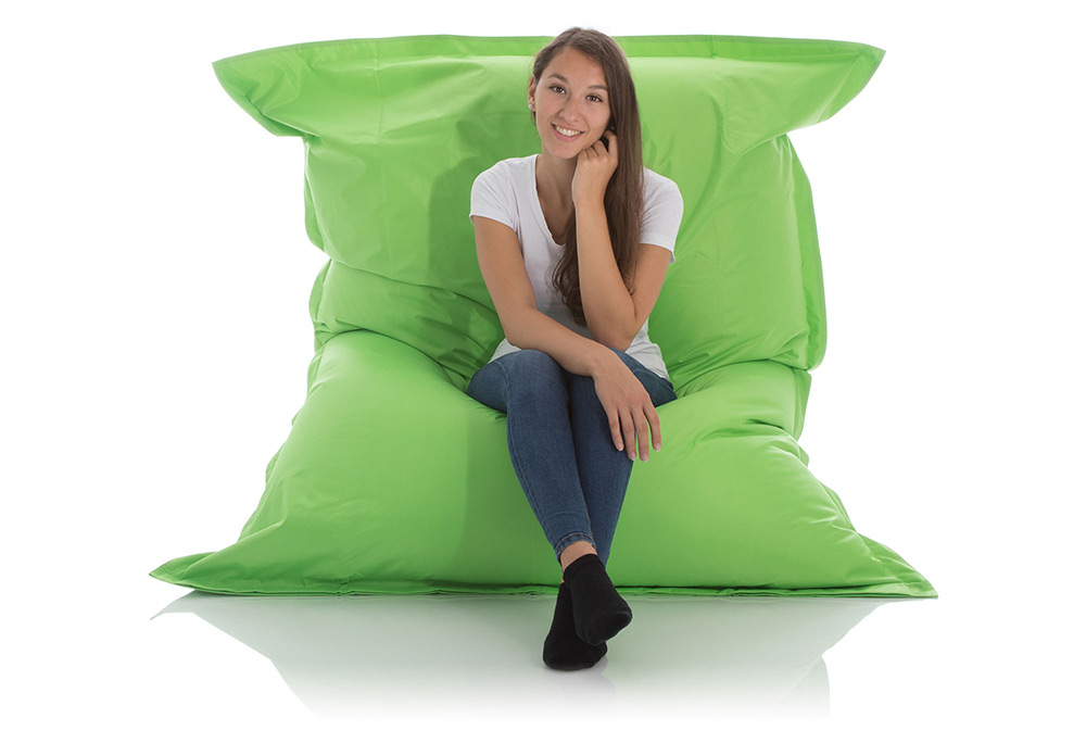 Junge Frau sitzt im aufrechten XXL Outdoor Sitzsack Fashion in grün