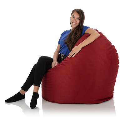 Junge Frau sitzt seitlich bequem in einem XXL Sitzsack Relax rot von frago